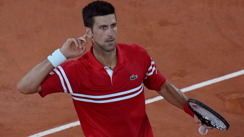 Novak Djokovic looking into crowd, holding hand to ear