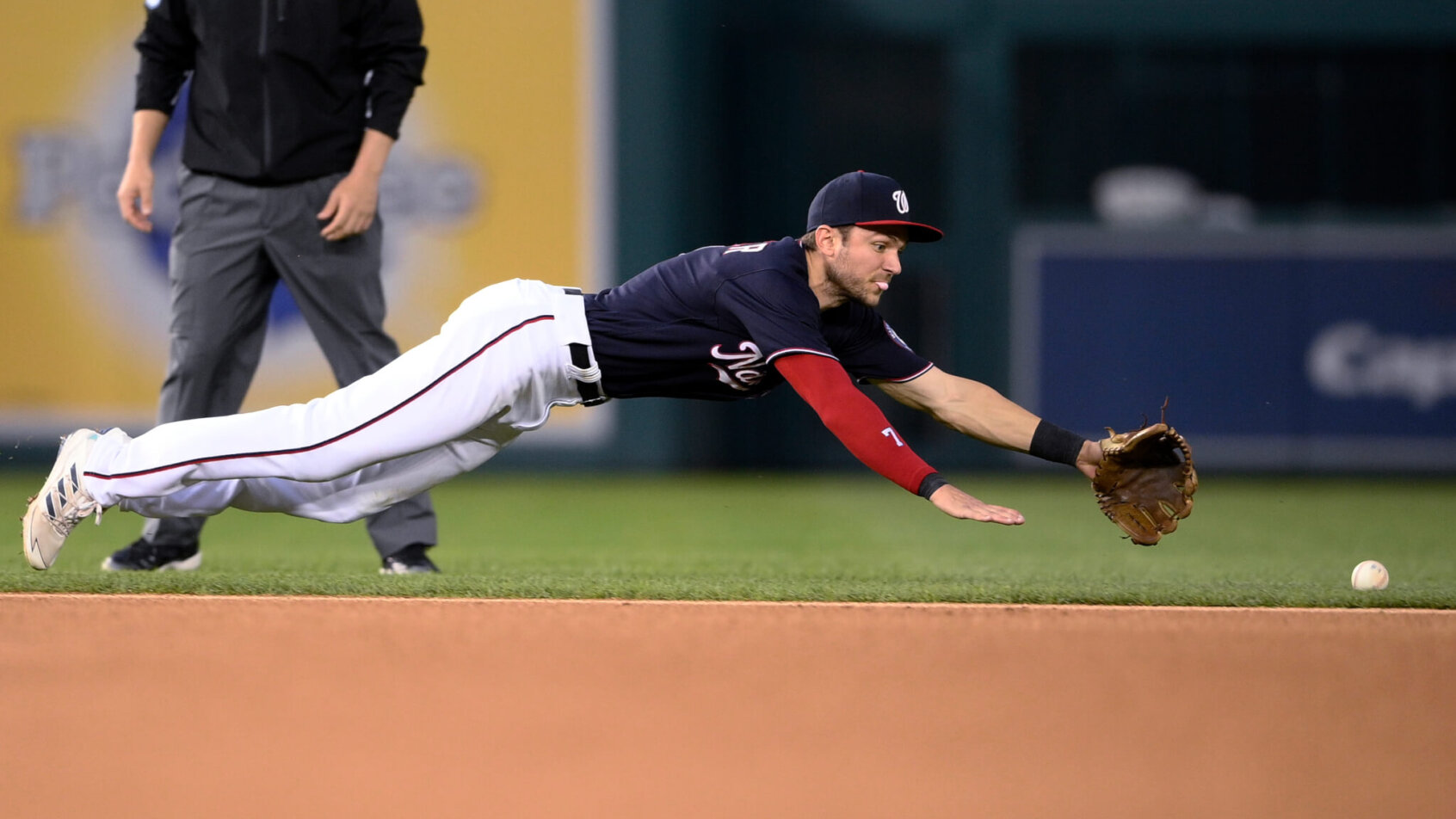 Shortstop Trea Turner diving for a ball during a MLB game.