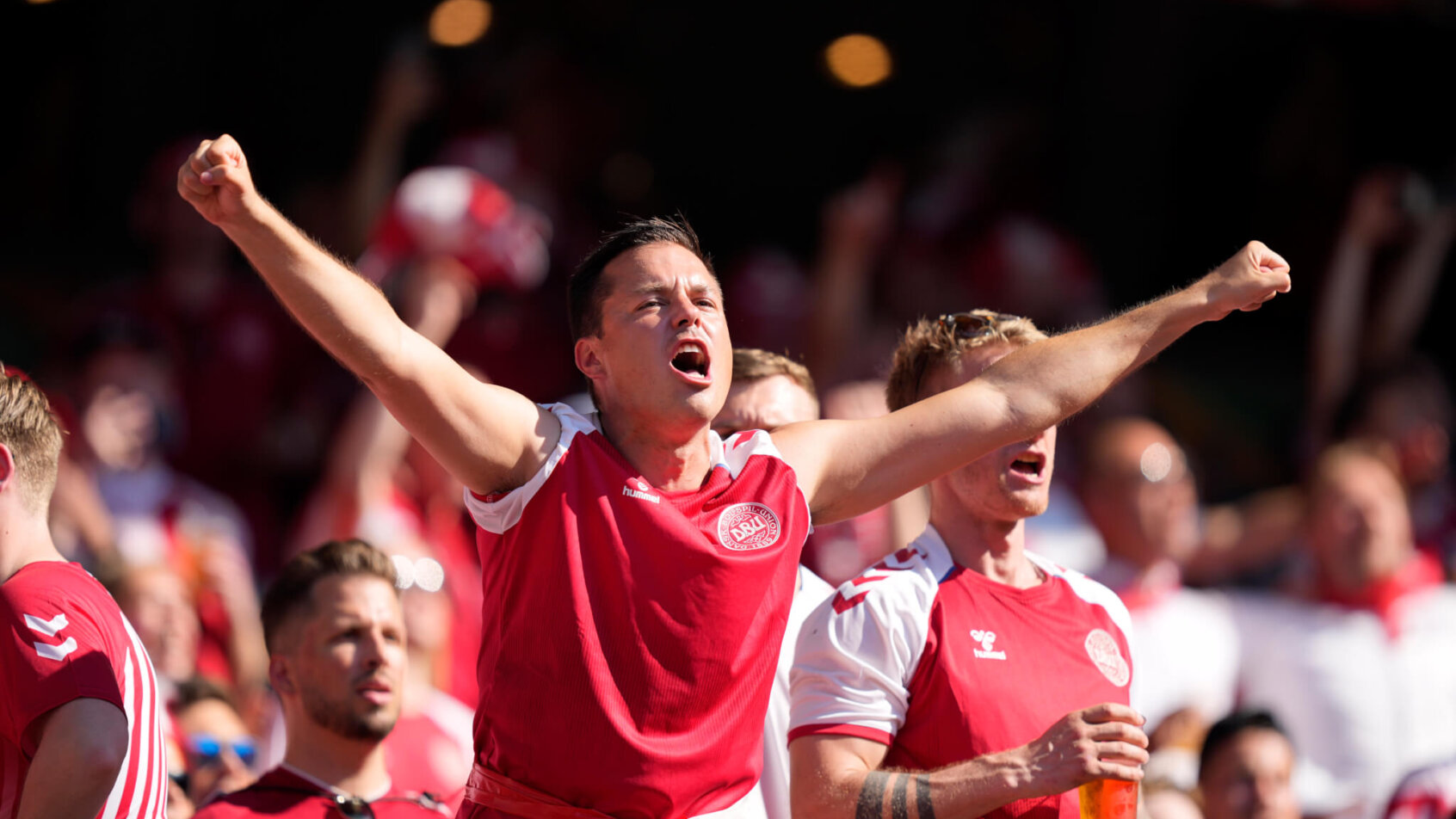 Danish fans cheering for their team during a soccer match.