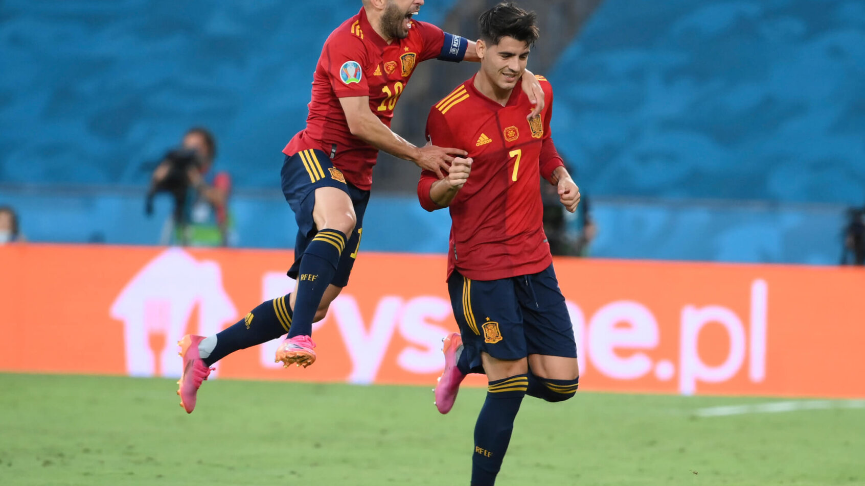 Spain's Alvaro Morata and Jordi Alba celebrating after scoring a goal during a soccer match.
