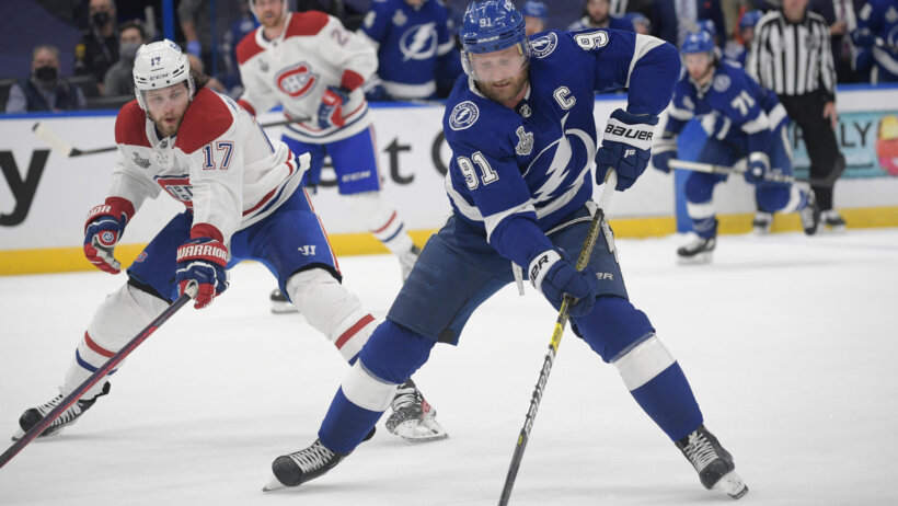 Steven Stamkos with puck and defender chasing him