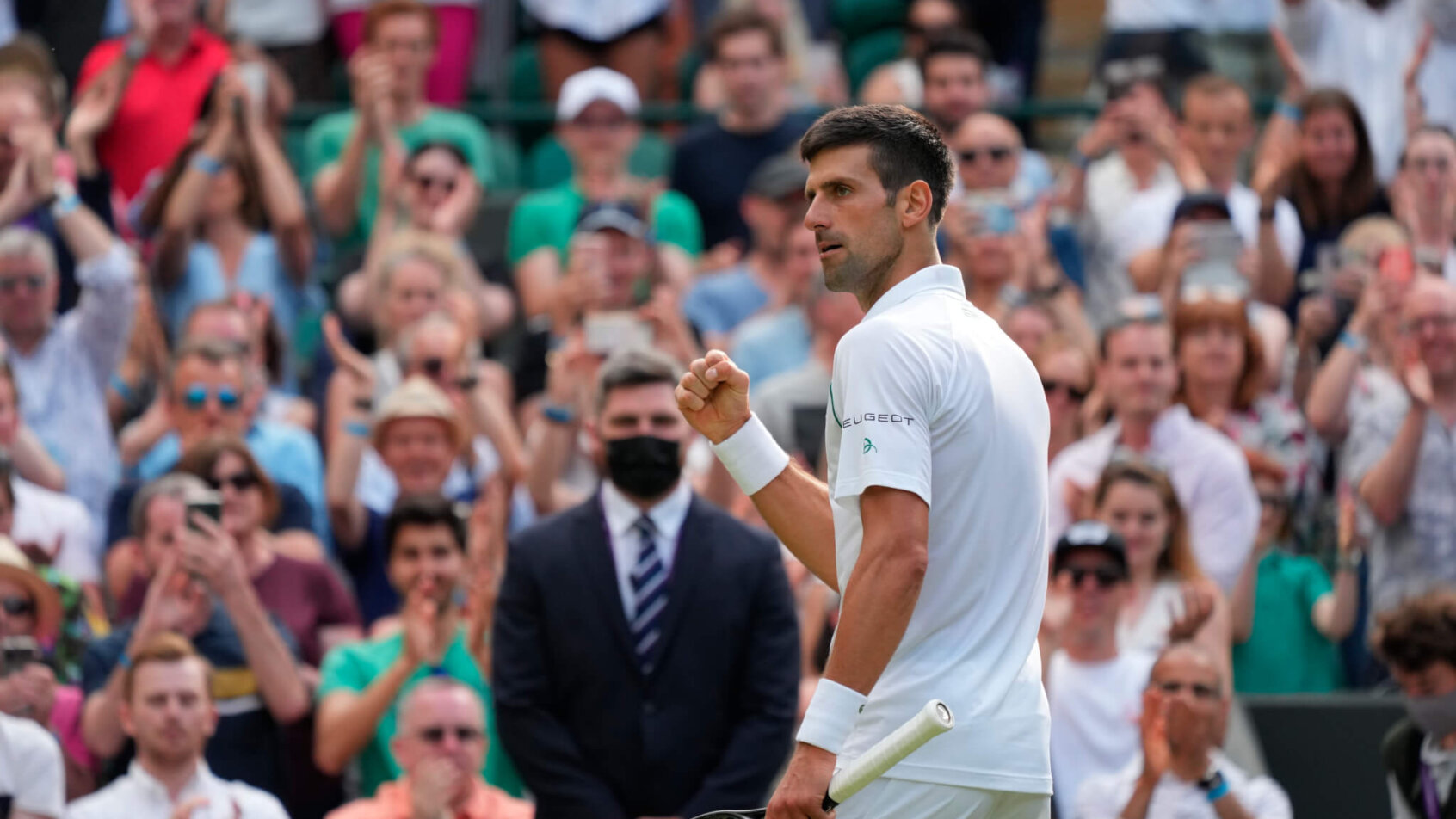 Novak Djokovic celebrating a win with a fist pump during a match at Wimbledon.