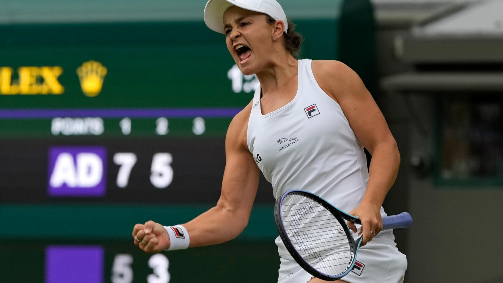 Ashleigh Barty celebrating with a fist pump after winning a match at Wimbledon.