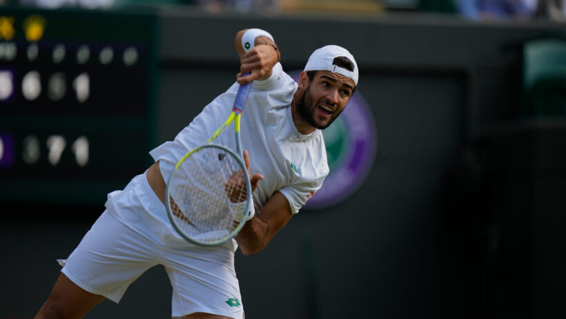 Matteo Berrettini hitting a return during a tennis match at Wimbledon.