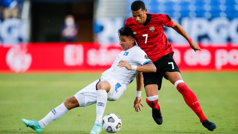 El Salvador defender Bryan Tamacas and Trinidad defender Ryan Telfer battling for the ball during a CONCACAF Gold Cup soccer match.
