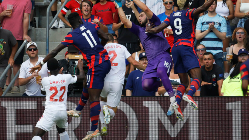 Maxime Crepeau of Canada, leaping to grab a corner kick goal attempt from the United States players.