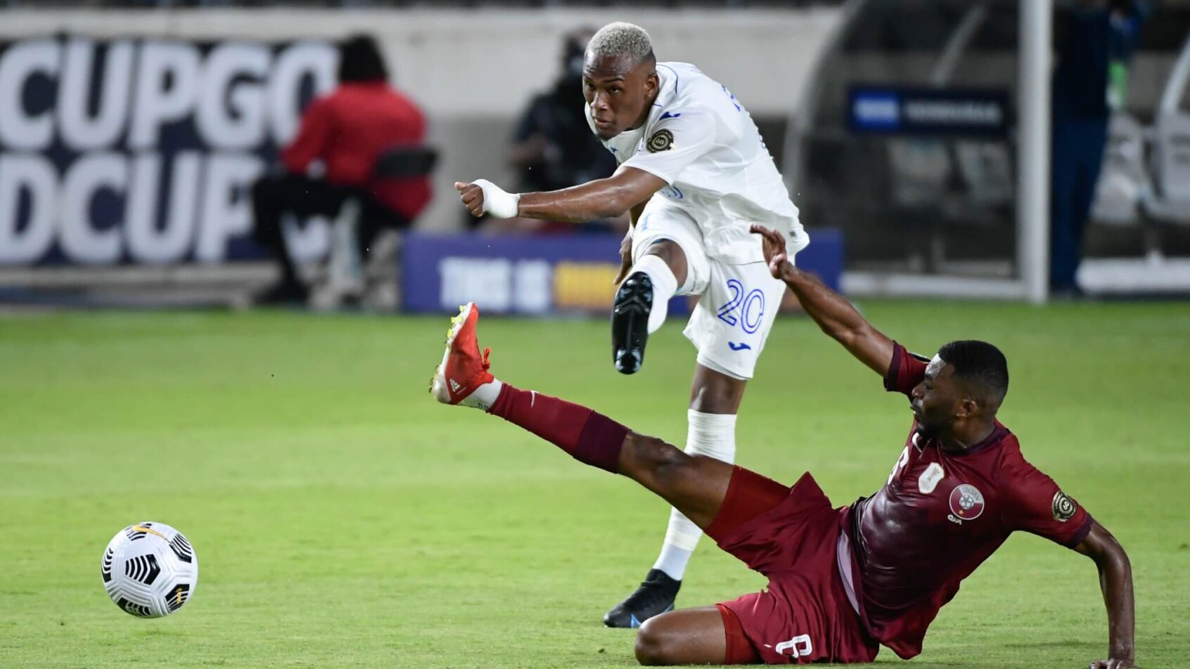 Deybi Flores kicks ball past sliding defender
