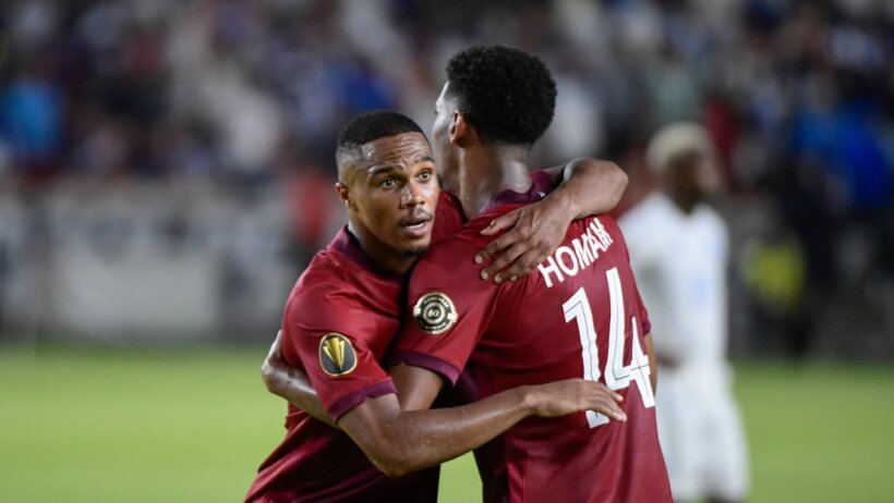 Qatar players embrace on the pitch
