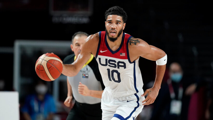 Jayson Tatum dribbling the ball up thee court during an Olympic basketball game.