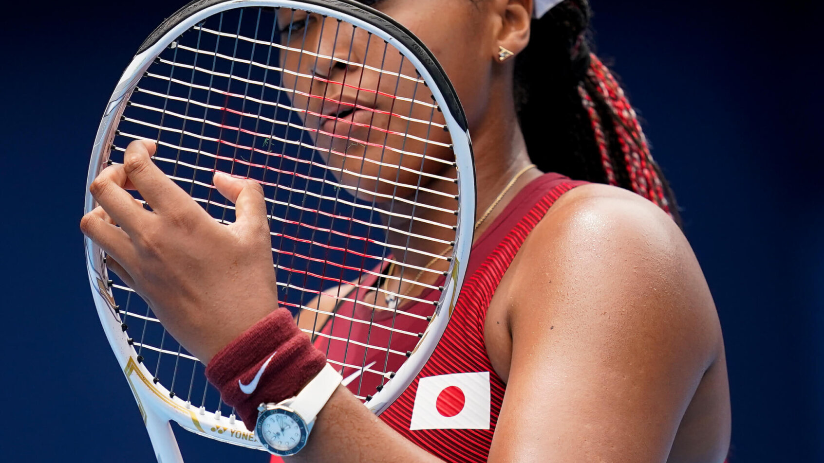 Naomi Osaka checking strings on racket
