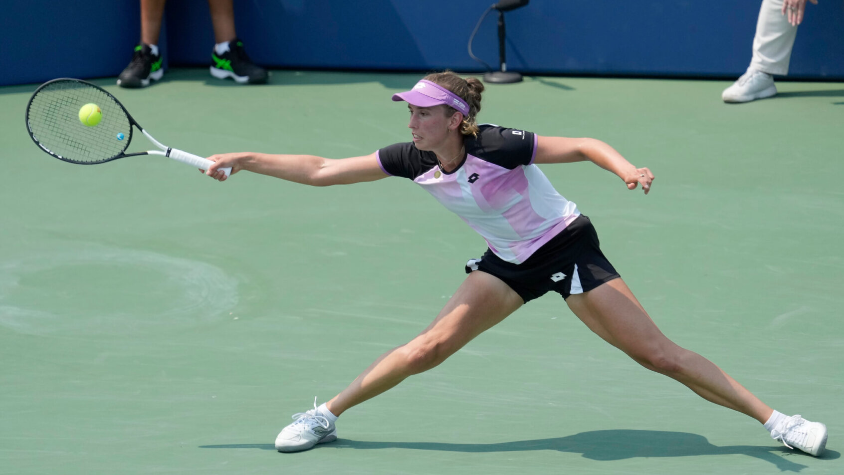 Elise Mertens stretching to return a forehand during a tennis match in San Jose.