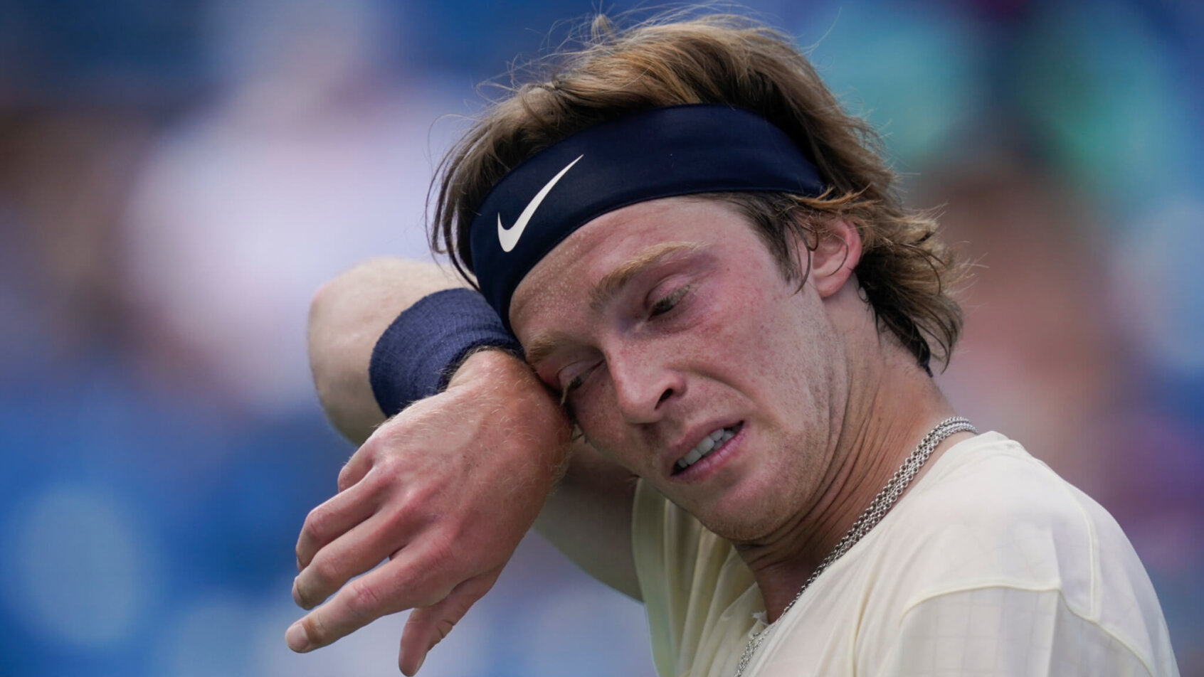 Andrey Rublev wiping face with wristband