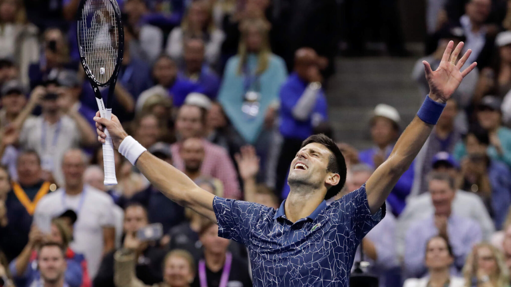 Novak Djokovic celebrating with his hands up in the air after a final.
