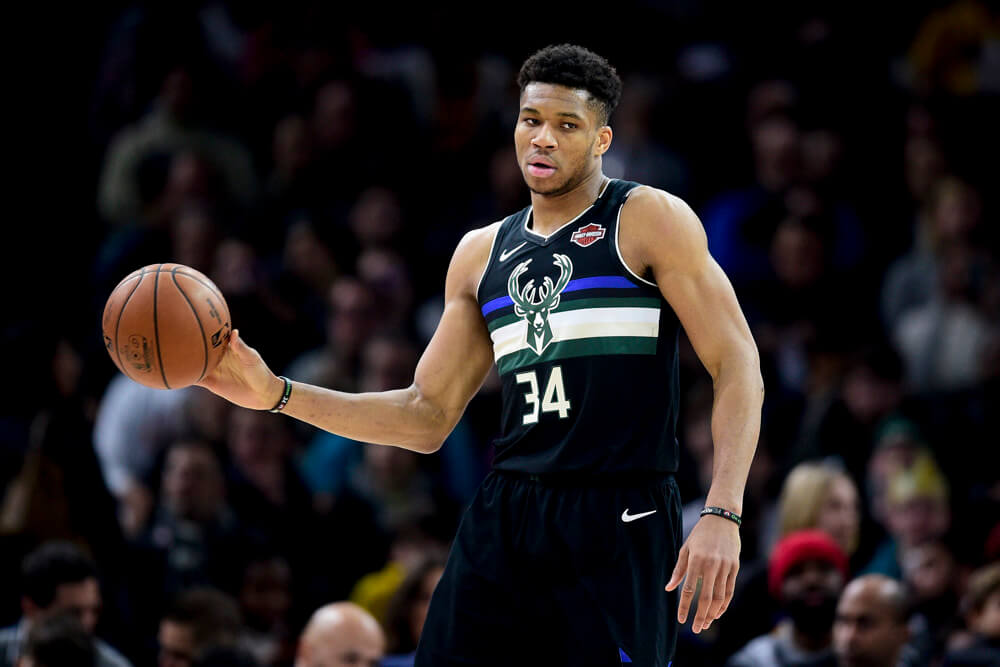 Giannis Antetokounmpo holding ball out with one hand