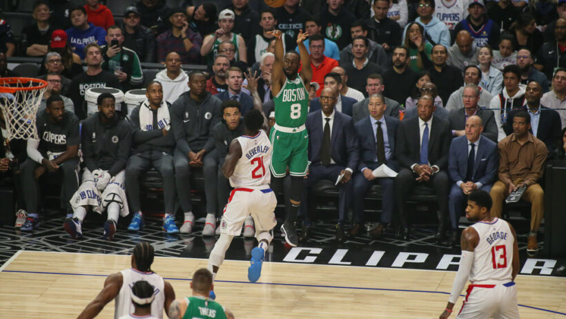 Kemba Walker shooting a three point shot from the corner during a NBA game.