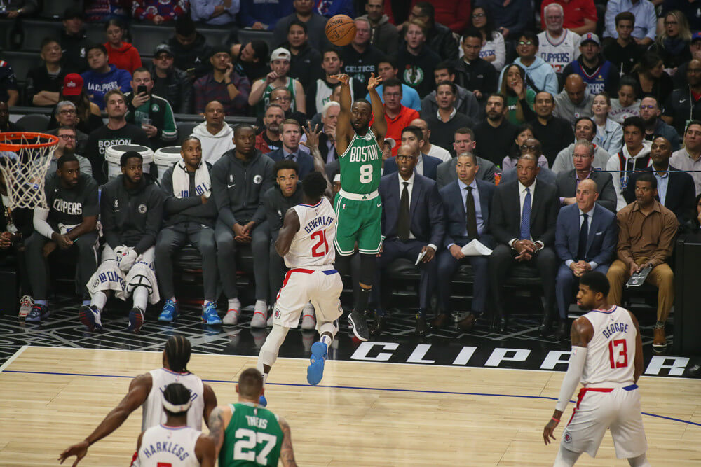 Kemba Walker shooting a three point shot from the corner during a NBA game.