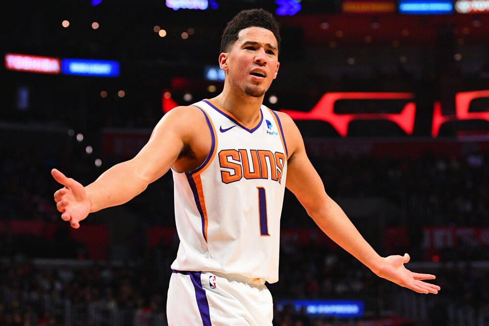 Devin Booker arms out looking at someone