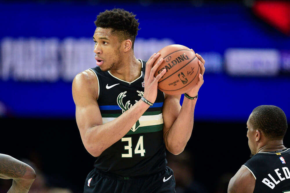 Giannis Antetokounmpo holding ball up near head with two hands