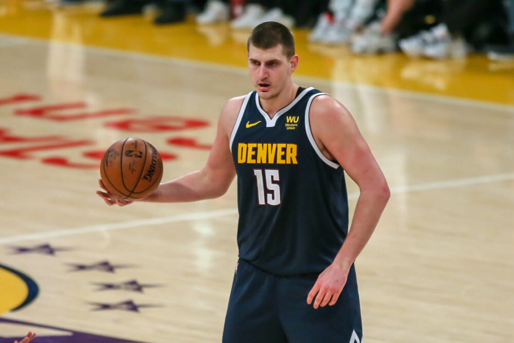 Nikola Jokic holding basketball at top of key
