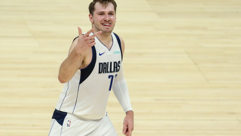 Luka Doncic holding up three fingers and sticking out tongue