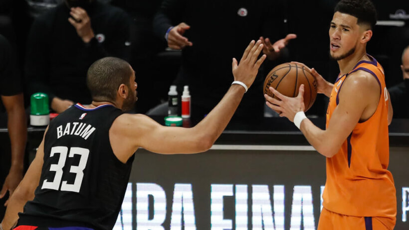 Devin Booker looking to make pass with a defender in front of him