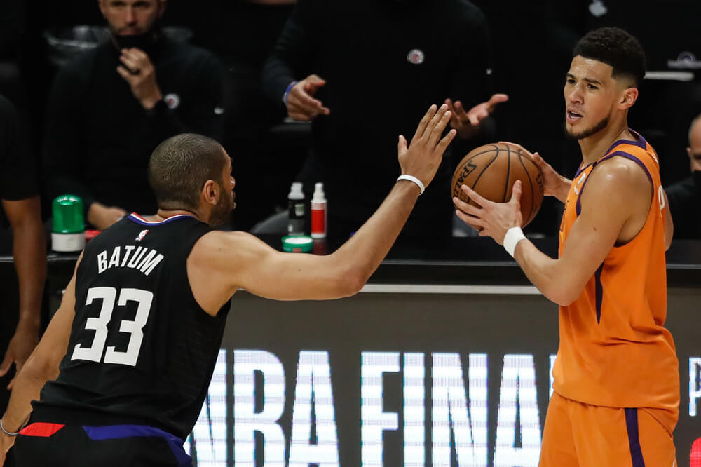 Devin Booker looking to make pass with a defender in front of him