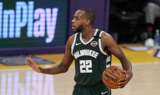 Khris Middleton holding ball on the court with hand out