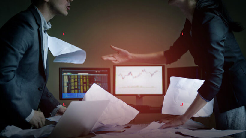 two professionals in an office arguing over documents