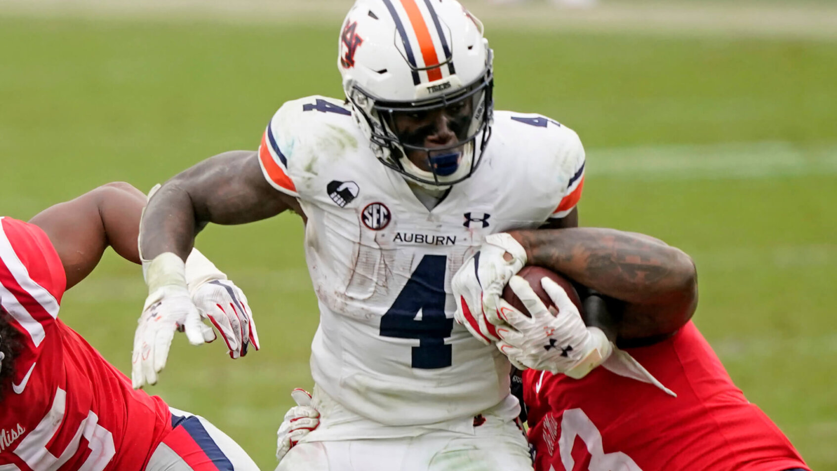 Auburn running back Tank Bigsby fighting off a tackle attempt by a Mississippi linebacker.
