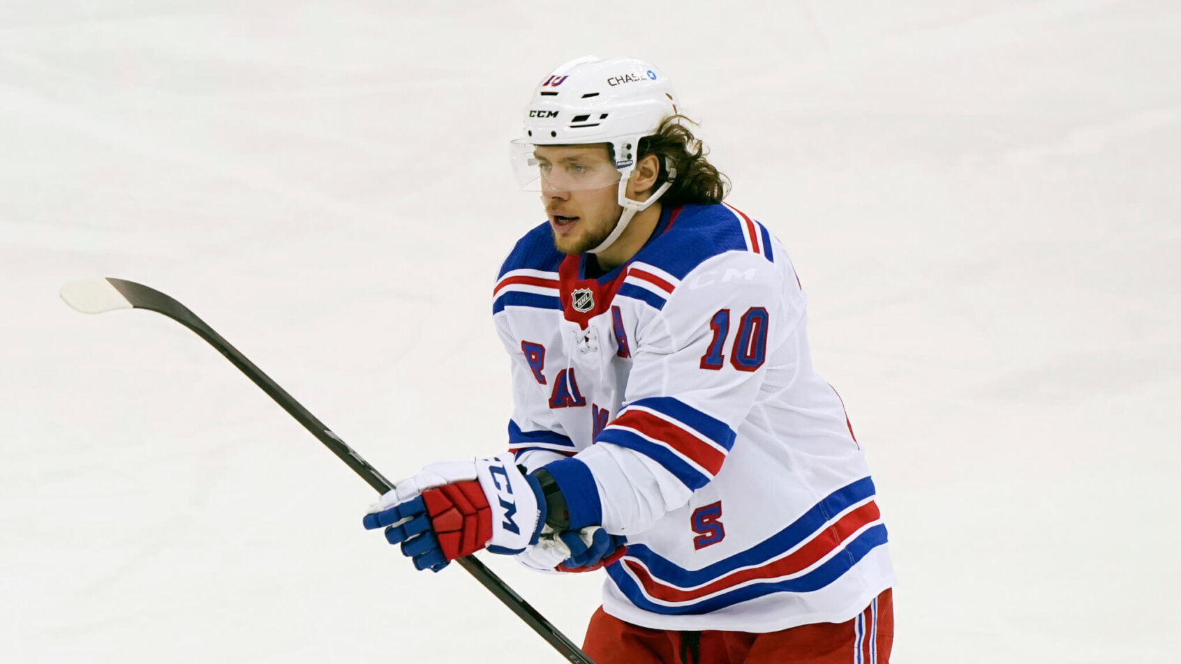 Artemi Panarin skating holding middle of hockey stick