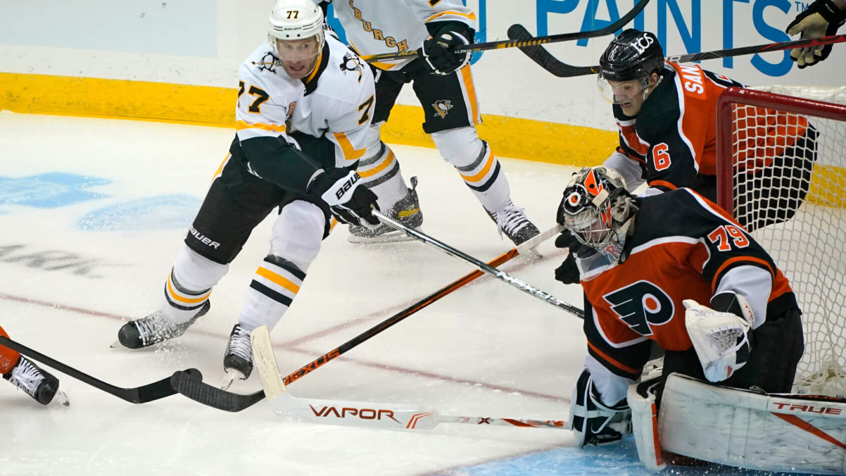 Pittsburgh Penguins' Jeff Carter attempting a wraparound past Philadelphia Flyers goalie Carter Hart during an NHL hockey game.
