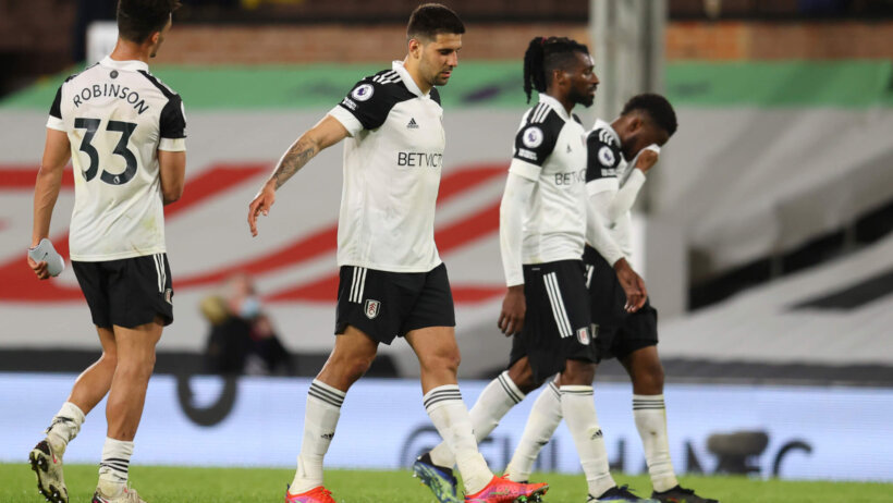 Fulham players walking on the pitch after an EPL soccer match.