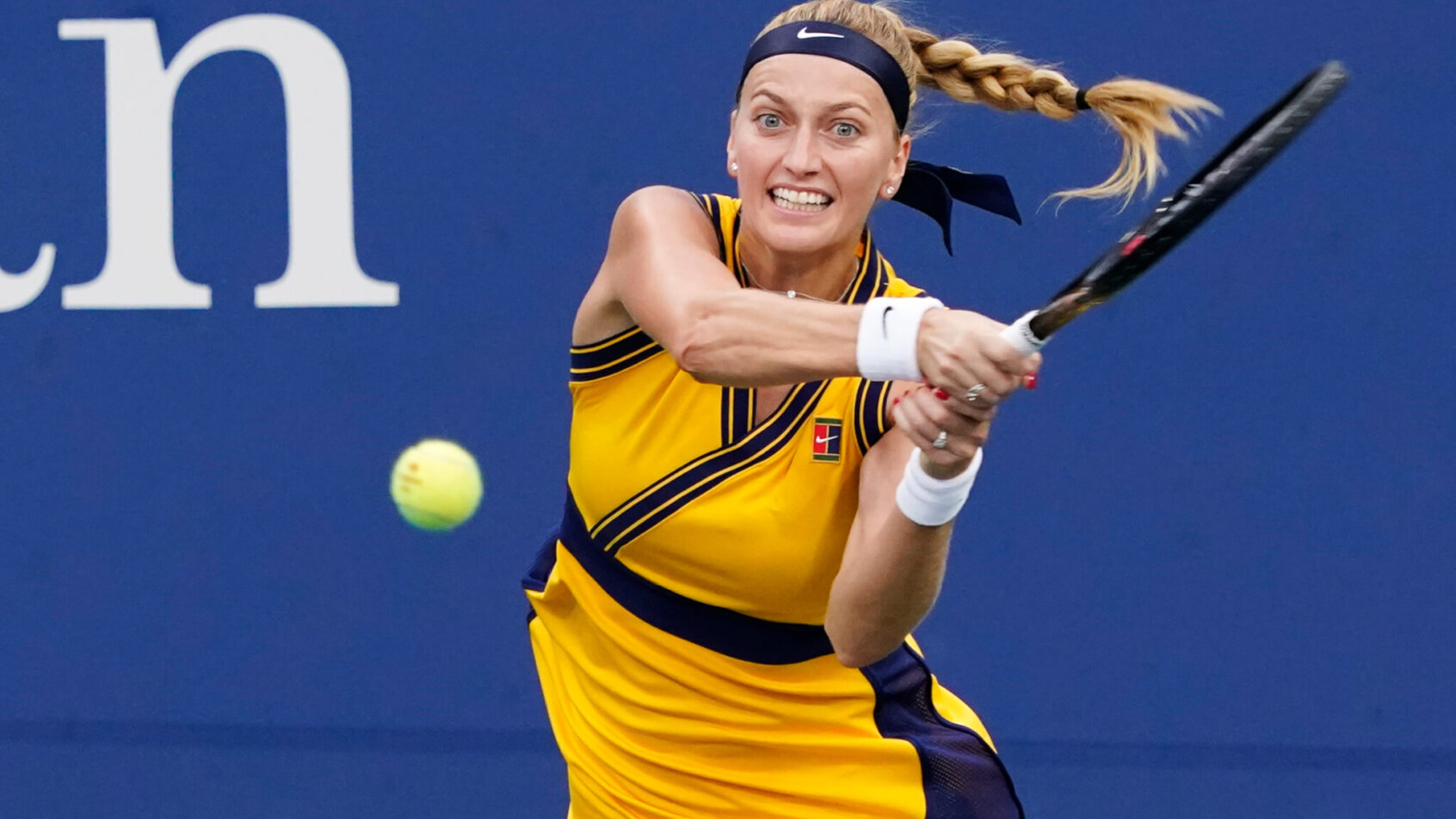 Petra Kvitova hitting a return shot during a tennis match.