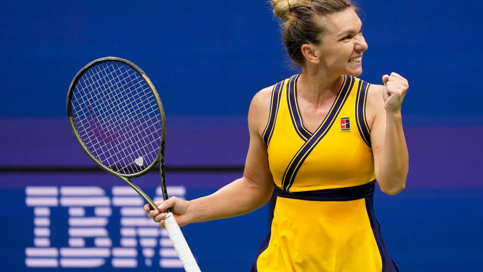 Simona Halep celebrating with a fist pump after winning a tennis match.