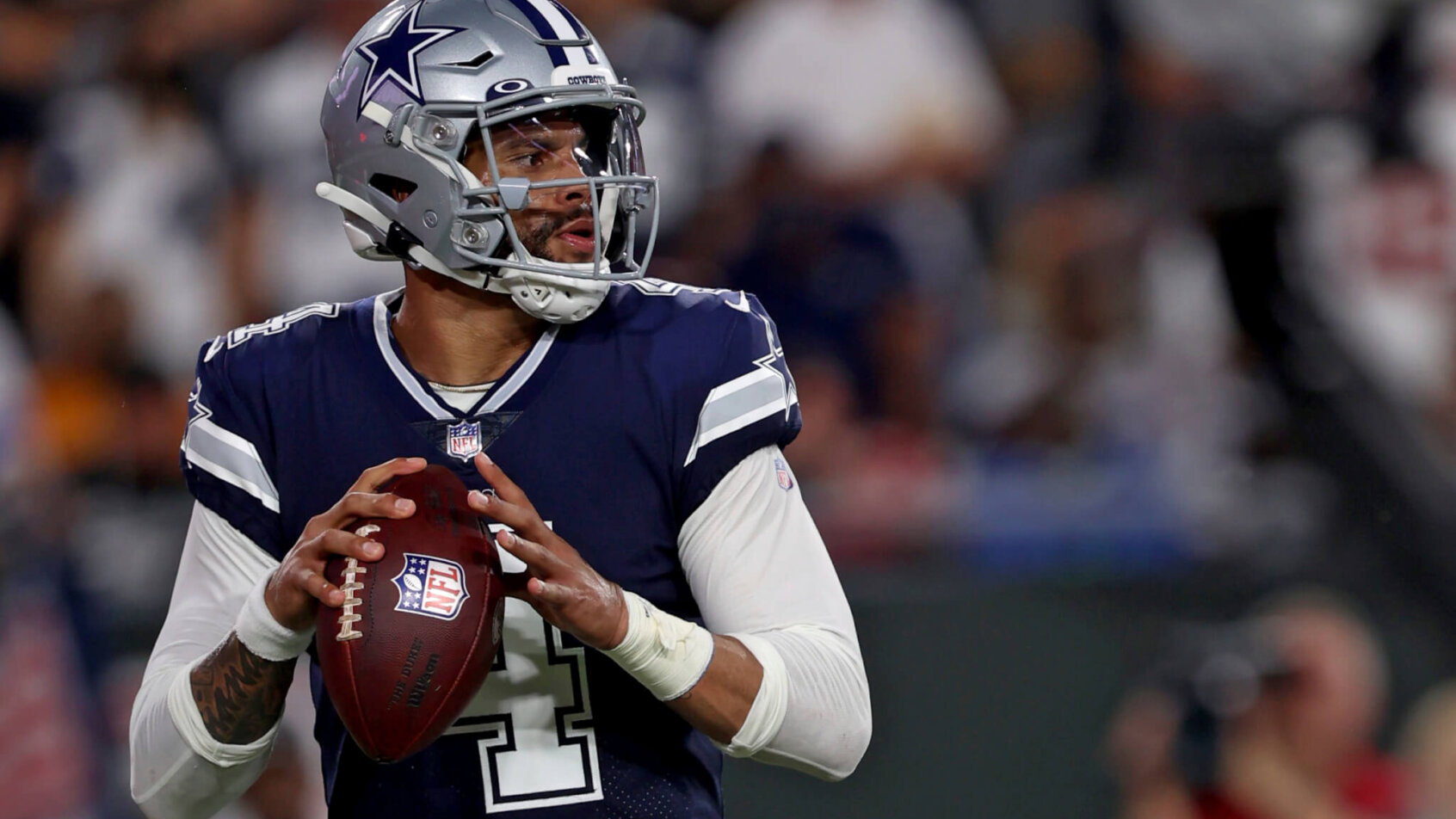 Dak Prescott getting ready to throw a pass during an NFL football game.