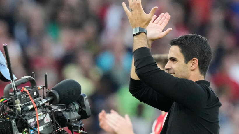 Arsenal's manager Mikel Arteta greeting supporters at the end of a soccer match.