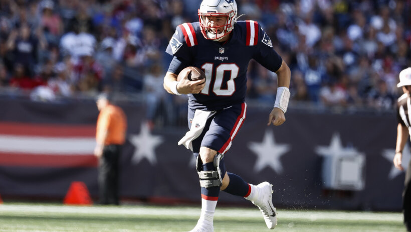 Mac Jones running with football