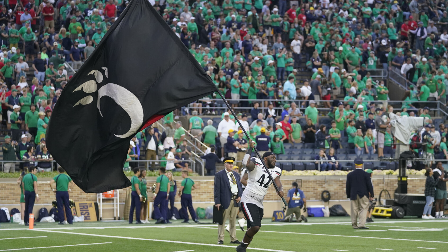 Cincinnati's Malik Vann running with his team flag