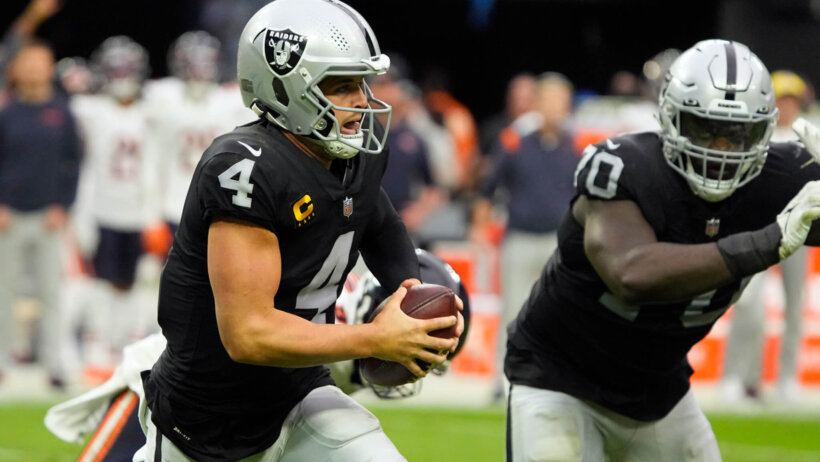 Las Vegas Raiders quarterback Derek Carr running with the ball during an NFL football game.