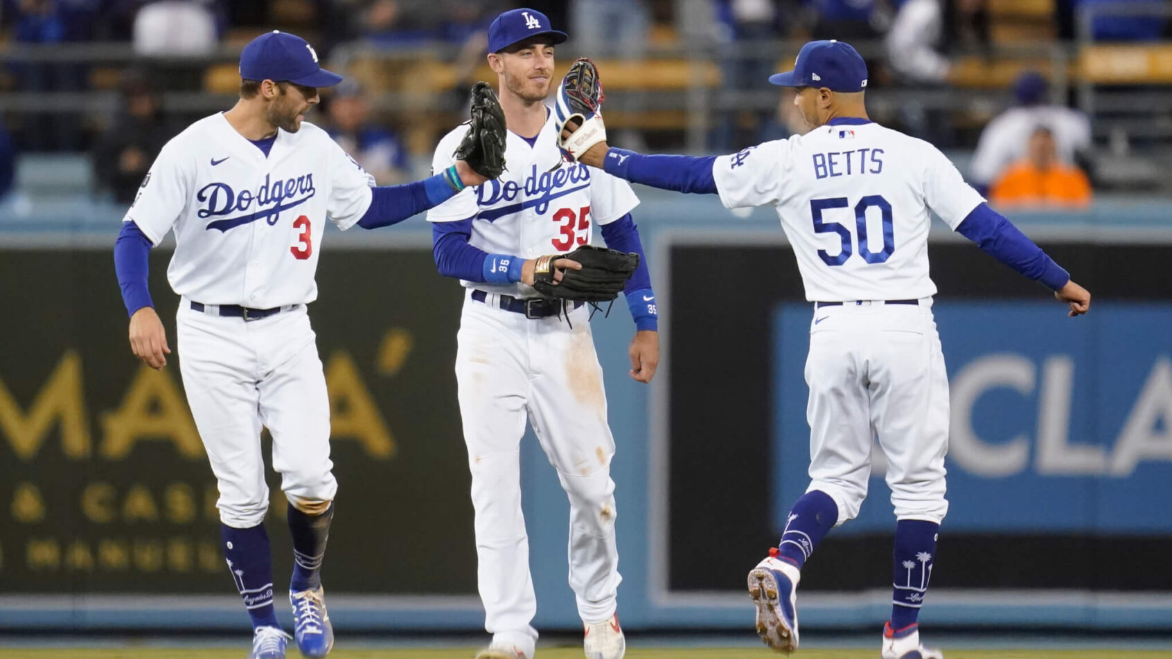 Los Angeles Dodgers' Chris Taylor, Cody Bellinger, and Mookie Betts celebrating a win
