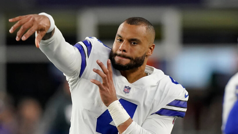Dak Prescott warms up on the sidelines