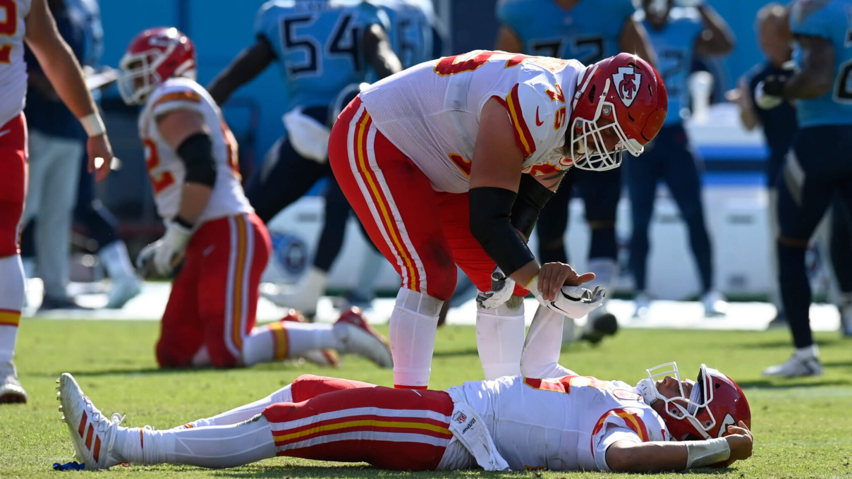 Patrick Mahomes laying on back, teammate trying to help him up