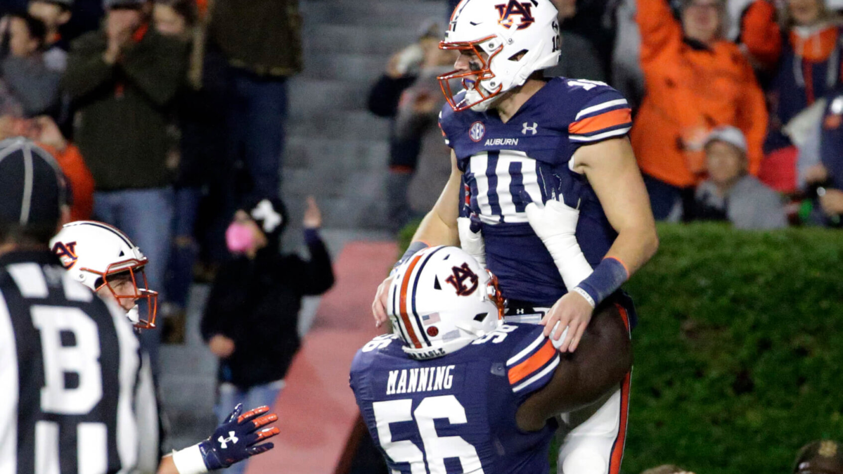 Auburn quarterback Bo Nix celebrating with a teammate after scoring a touchdown.