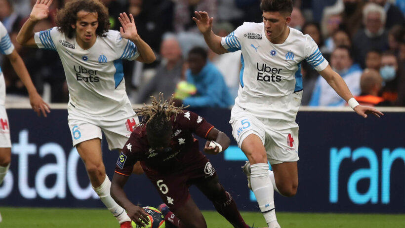 Marseille players challenging Metz player