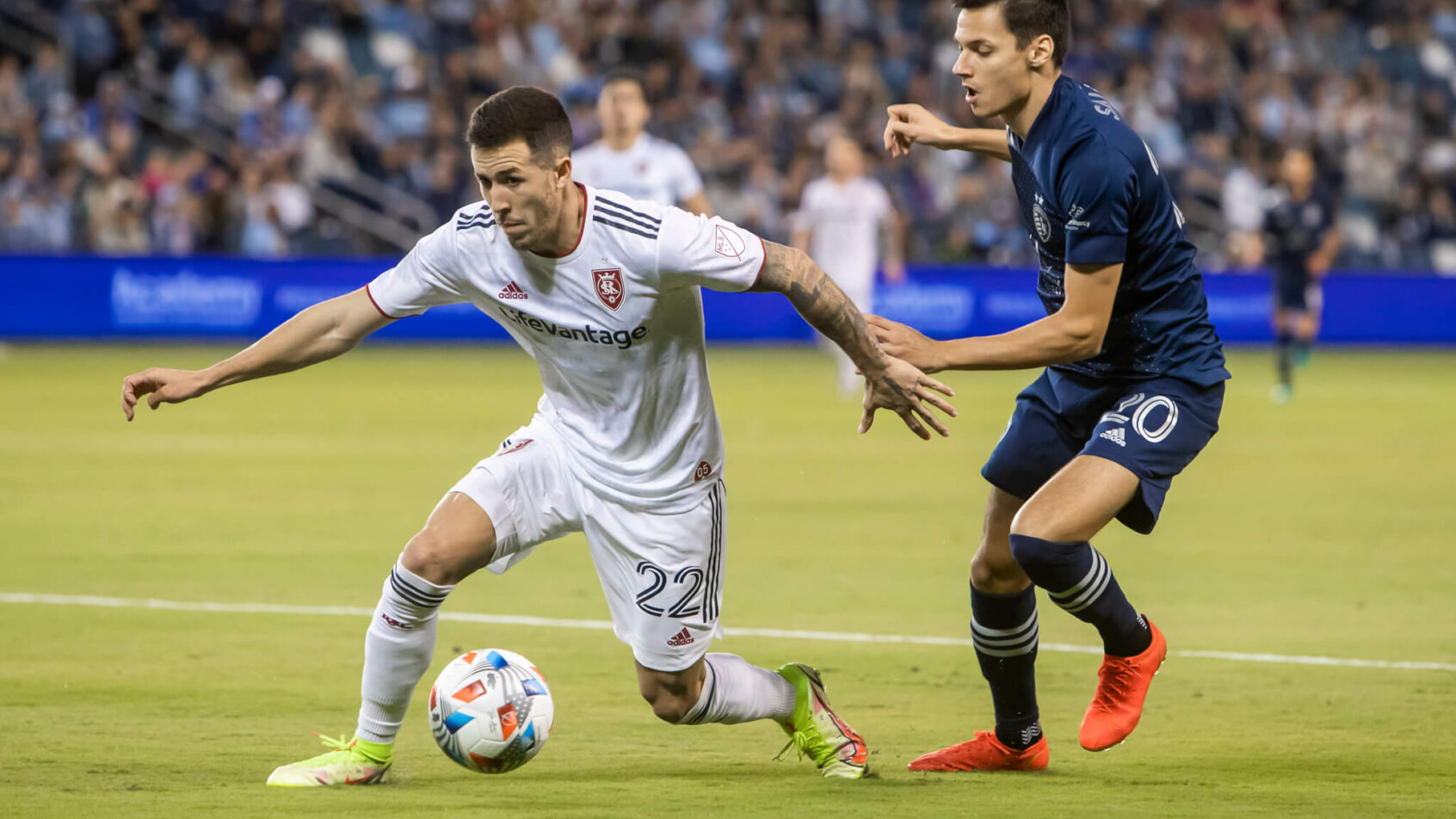 Real Salt Lake defender Aaron Herrera gains control of the ball over Sporting Kansas City forward Daniel Salloi during the first half of a soccer match.