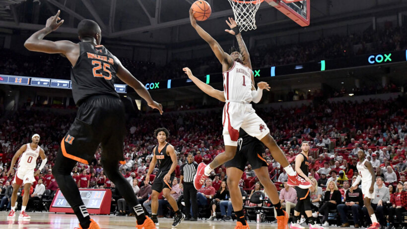 Arkansas guard JD Notae driving past Mercer guard Shawn Walker Jr. during an NCAA college basketball game.