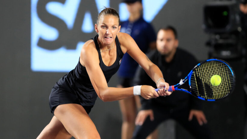 Karolina Pliskova hitting a return shot during a tennis match at the WTA Finals.