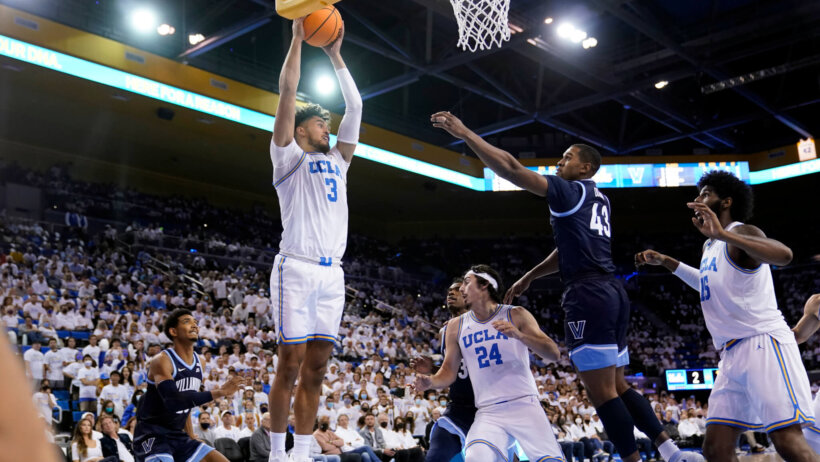 Johnny Juzang jumping up and rebounding basketball