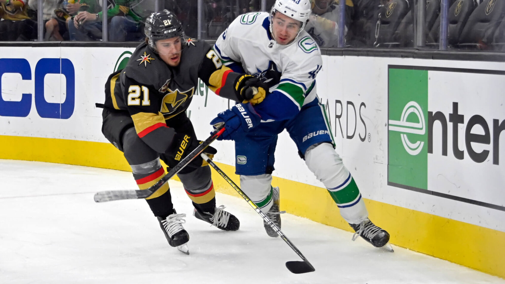 Brett Howden and Quinn Hughes battle for puck