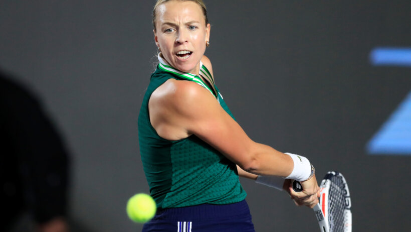 Anett Kontaveit hitting a return shot during a tennis match.